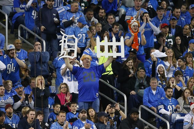 A Detroit Lions fan holds up defense placards during the second quarter of an NFL football game Green Bay Packers at Ford Field in Detroit, Thursday, Nov. 28, 2013. (AP Photo/Rick Osentoski)