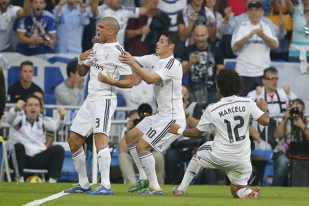 Real Madrid's Pepe, left, celebrates his goal with teammates James Rodriguez, center, and Marcelo during a Spanish La Liga soccer match between Real Madrid and FC Barcelona at the Santiago Bernabeu stadium in Madrid, Spain, Saturday, Oct. 25, 2014. (AP Photo/Andres Kudacki)