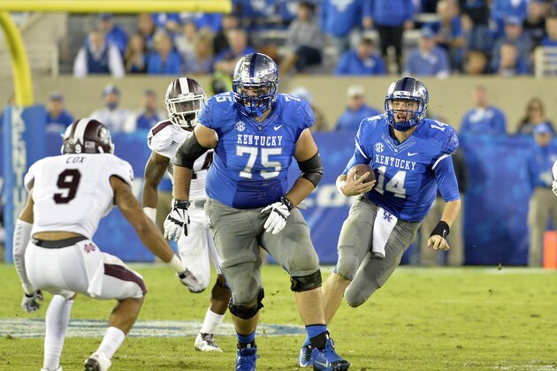 Kentucky's Patrick Towles, right, runs through an opening in the Mississippi State defense during the third quarter of an NCAA college football game at Commonwealth Stadium in Lexington, Ky., Saturday, Oct. 25, 2014. Mississippi State won 45-31. (AP Photo/Timothy D. Easley)