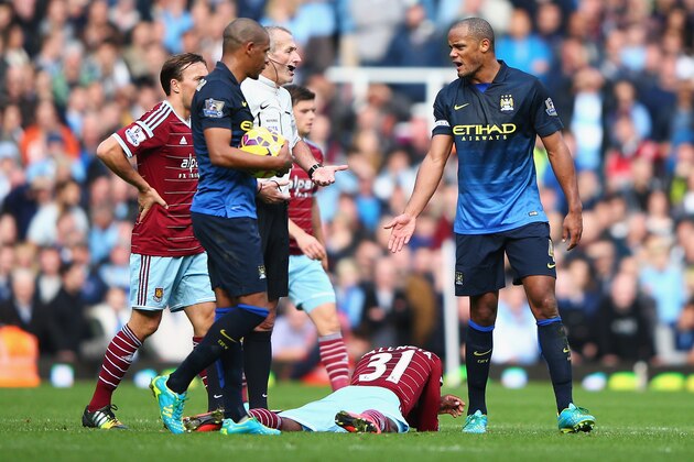 LONDON, ENGLAND - OCTOBER 25:  Referee Martin Atkinson talks to Vincent Kompany of Manchester City during the Barclays Premier League match between West Ham United and Manchester City at Boleyn Ground on October 25, 2014 in London, England.  (Photo by Ian Walton/Getty Images)