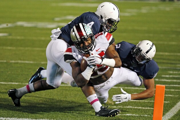 Ohio State running back Ezekiel Elliott (15) dives across the goal line for a touchdown with Penn State safety Adrian Amos (4) and Marcus Allen (2) defending during the first quarter an NCAA college football game in State College, Pa., Saturday, Oct. 25, 2014. (AP Photo/Gene J. Puskar)