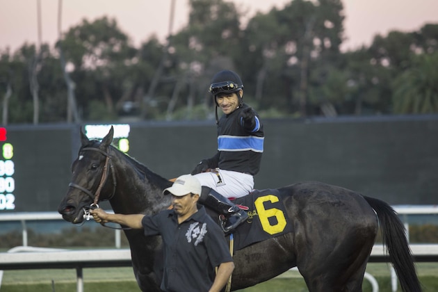 Jockey Corey Nakatani celebrates aboard Shared Belief after winning the CashCall Futurity horse race at Betfair Hollywood Park in Inglewood, Calif., on Saturday, Dec. 14, 2013. (AP Photo/Ringo H.W. Chiu)