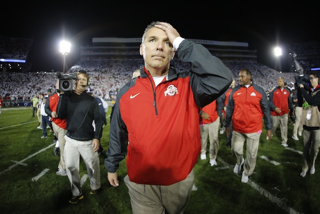 In this photo taken with a fisheye lens Ohio State coach Urban Meyer walks off the field after a 31-24 win in double overtime over Penn State in an NCAA college football game in State College, Pa., Sunday, Oct. 26, 2014. (AP Photo/Gene J. Puskar)