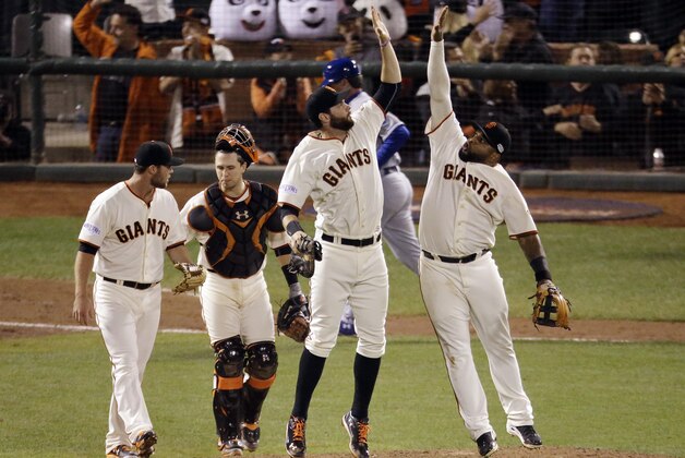 San Francisco Giants' Pablo Sandoval, right, leaps for a high five with Brandon Belt as catcher Buster Posey and pitcher Hunter Strickland, far left, walk off the field after Game 4 of baseball's World Series against the Kansas City Royals on Saturday, Oct. 25, 2014, in San Francisco. The Giants won the game 11-4 to tie the series 2-2.  (AP Photo/Charlie Riedel)
