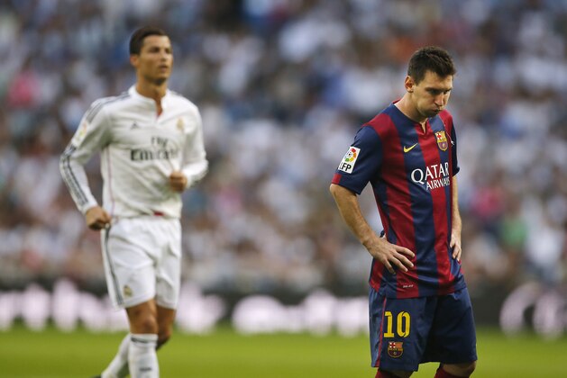 Real Madrid's Cristiano Ronaldo, left, runs as Barcelona's Lionel Messi, gestures  during a Spanish La Liga soccer match between Real Madrid and FC Barcelona at the Santiago Bernabeu stadium in Madrid, Spain, Saturday, Oct. 25, 2014. (AP Photo/Andres Kudacki)