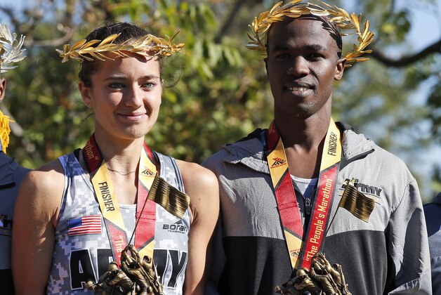 First place female finisher Meghan Curran, left, from Moorestown, N.J., and first place male finisher Samuel Kosgei, from Junction City, Kan., wearing their laurel wreaths and holding their trophies, which depict the Iwo Jima Memorial, pose for photo after the running of the 39th Marine Corps Marathon, Sunday, Oct. 26, 2014 in Arlington, Va. The race includes runners from 59 nations and each branch of the U.S. armed forces.  (AP Photo/Alex Brandon)