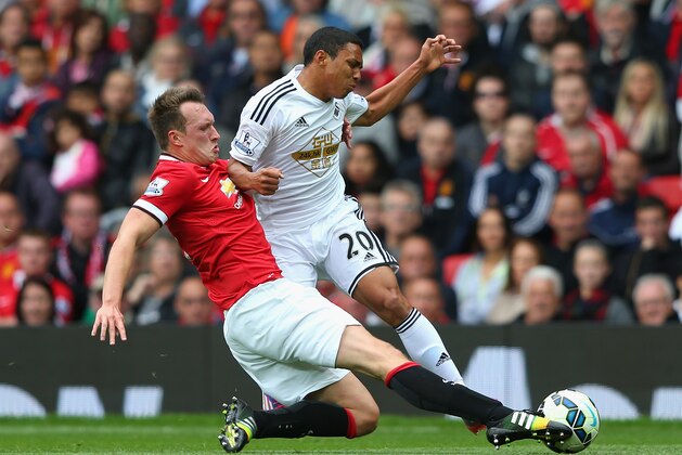 MANCHESTER, ENGLAND - AUGUST 16:  Phil Jones of Manchester United tackles Jefferson Montero of Swansea City during the Barclays Premier League match between Manchester United and Swansea City at Old Trafford on August 16, 2014 in Manchester, England.  (Photo by Alex Livesey/Getty Images)