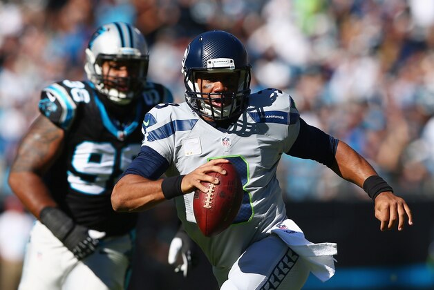 CHARLOTTE, NC - OCTOBER 26:   Russell Wilson #3 of the Seattle Seahawks scrambles from the Carolina Panthers defense in the 3rd quarter during the game at Bank of America Stadium on October 26, 2014 in Charlotte, North Carolina.  (Photo by Streeter Lecka/Getty Images)