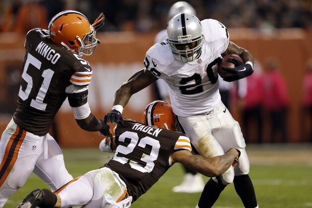 Oakland Raiders running back Darren McFadden is stopped for a loss by Cleveland Browns cornerback Joe Haden (23) and outside linebacker Barkevious Mingo (51) in the third quarter of an NFL football game Sunday, Oct. 26, 2014, in Cleveland. (AP Photo/Tony Dejak)