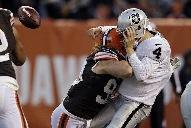 Oakland Raiders quarterback Derek Carr (4) is hit by Cleveland Browns outside linebacker Paul Kruger in the third quarter of an NFL football game Sunday, Oct. 26, 2014, in Cleveland. (AP Photo/Tony Dejak)