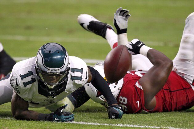 Philadelphia Eagles wide receiver Josh Huff (11) fumbles as Arizona Cardinals defensive end Frostee Rucker (98) falls during the first half of an NFL football game, Sunday, Oct. 26, 2014, in Glendale, Ariz. The Cardinals recovered the ball. (AP Photo/Ross D. Franklin)