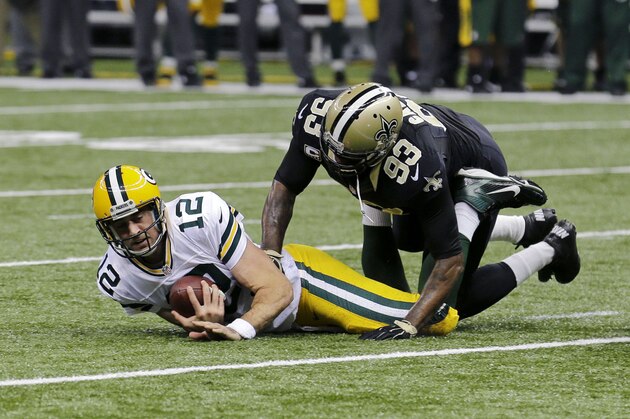 Green Bay Packers quarterback Aaron Rodgers (12) reacts after being sacked by New Orleans Saints outside linebacker Junior Galette (93) and defensive end Cameron Jordan (94), not pictured, in the first half of an NFL football game in New Orleans, Sunday, Oct. 26, 2014. (AP Photo/Bill Haber)