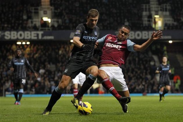 West Ham United's Winston Reid, right, competes with Manchester City's Edin Dzeko during their English Premier League soccer match at Upton Park, London, Saturday, Nov. 3, 2012. (AP Photo/Sang Tan)