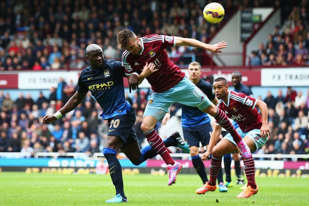 LONDON, ENGLAND - OCTOBER 25: Eliaquim Mangala of Manchester City challenges for a header with Carl Jenkinson of West Ham United during the Barclays Premier League match between West Ham United and Manchester City at Boleyn Ground on October 25, 2014 in London, England.  (Photo by Ian Walton/Getty Images)