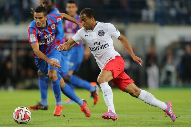 Paris Saint Germain's forward Lucas Moura of Brazil, right, takes a shot at goal to score the first goal past Caen's defender Jean Calve during their League One soccer match, in Caen, western France, Wednesday, Sept. 24, 2014. (AP Photo/David Vincent)