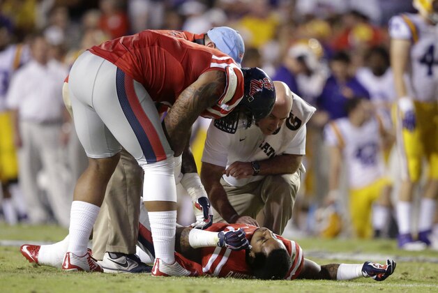 Mississippi defensive tackle Robert Nkemdiche (5) stands over his brother linebacker Denzel Nkemdiche (4) after he was injured in the first half of an NCAA college football game against LSU in Baton Rouge, La., Saturday, Oct. 25, 2014. (AP Photo/Gerald Herbert)
