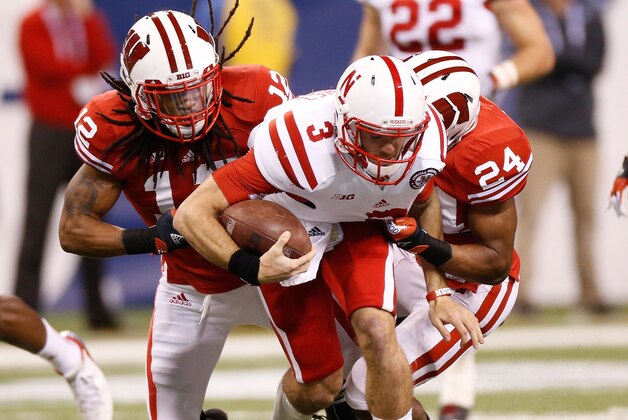 INDIANAPOLIS, IN - DECEMBER 01: Taylor Martinez #3 of the Nebraska Cornhuskers is tackled during a first quarter run by Dezmen Southward #12 and Shelton Johnson #24 of the Wisconsin Badgers during the Big 10 Conference Championship Game at Lucas Oil Stadium on December 1, 2012 in Indianapolis, Indiana.  (Photo by Gregory Shamus/Getty Images)