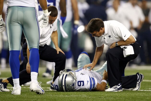 Dallas Cowboys' Tony Romo (9) is looked at by team staff after being sacked by Washington Redskins' Keenan Robinson during the second half of an NFL football game, Monday, Oct. 27, 2014, in Arlington, Texas. Romo was injured on the play. (AP Photo/Tim Sharp)