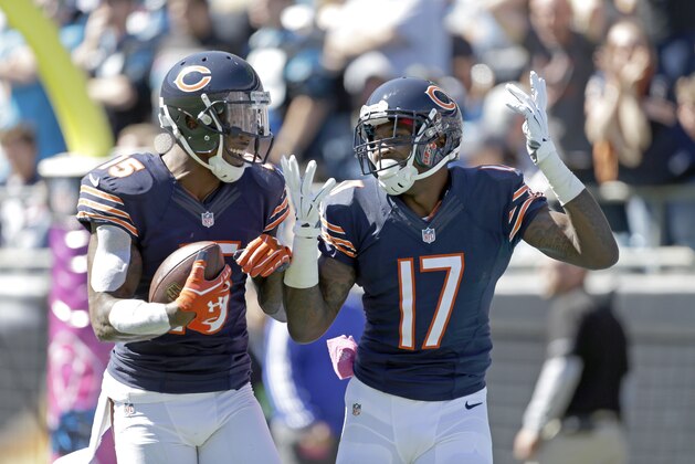 The Chicago Bears' Brandon Marshall (15) holds the touchdown football as he celebrates his teammate's Alshon Jeffery (17) score during the first half of an NFL football game against the Carolina Panthers in Charlotte, N.C., Sunday, Oct. 5, 2014. The Panthers won 31-24. (AP Photo/Bob Leverone)