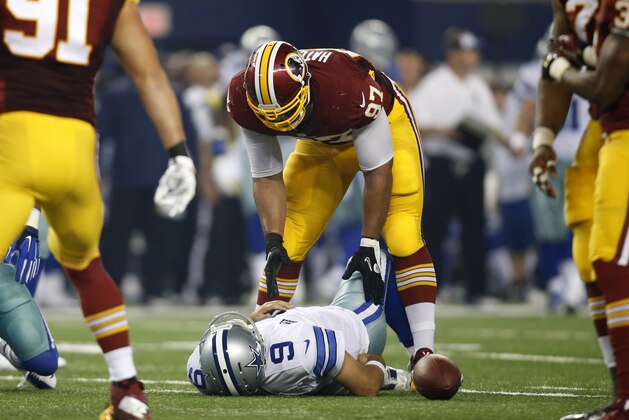 Washington Redskins' Jason Hatcher (97) check son Dallas Cowboys quarterback Tony Romo (9) who lays on the ground injured after being sacked by the Redskins' Keenan Robinson during the second half of an NFL football game, Monday, Oct. 27, 2014, in Arlington, Texas. (AP Photo/Tim Sharp)