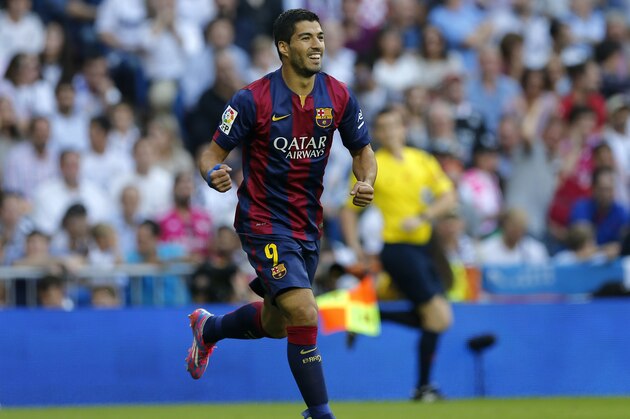 Barcelona's Luis Suarez, celebrates after Barcelona's Neymar scored during a Spanish La Liga soccer match between Real Madrid and Barcelona at the Santiago Bernabeu stadium in Madrid, Spain, Saturday Oct. 25, 2014. (AP Photo/Paul White)