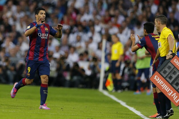 Barcelona's Luis Suarez, left, leaves the pitch, to be replaced by Barcelona's Pedro Rodriguez, 2nd right, after being substituted during a Spanish La Liga soccer match between Real Madrid and Barcelona at the Santiago Bernabeu stadium in Madrid, Spain, Saturday Oct. 25, 2014. (AP Photo/Paul White)
