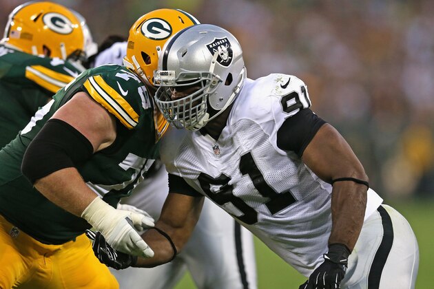 GREEN BAY, WI - AUGUST 22:  Justin Tuck #91 of the Oakland Raiders rushes against  Bryan Bulaga #75 of the Green Bay Packers during a preseason game at Lambeau Field on August 22, 2014 in Green Bay, Wisconsin. The Packers defeated the Raiders 31-21.  (Photo by Jonathan Daniel/Getty Images)