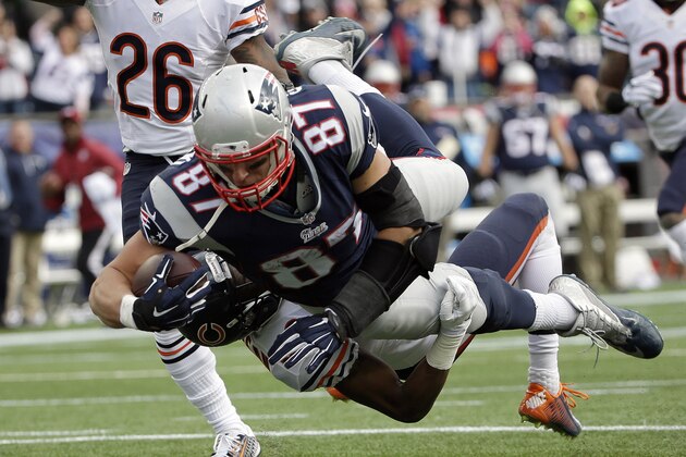 New England Patriots tight end Rob Gronkowski (87) carries Chicago Bears defensive back Al Louis-Jean (39) into the end zone while scoring a touchdown in the second half of an NFL football game on Sunday, Oct. 26, 2014, in Foxborough, Mass. (AP Photo/Steven Senne)