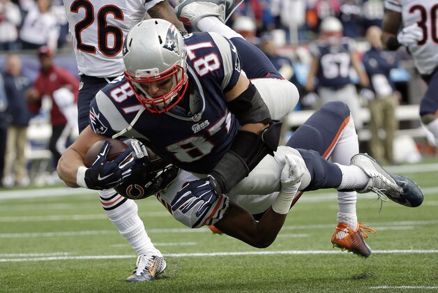 New England Patriots tight end Rob Gronkowski (87) carries Chicago Bears defensive back Al Louis-Jean (39) into the end zone while scoring a touchdown in the second half of an NFL football game on Sunday, Oct. 26, 2014, in Foxborough, Mass. (AP Photo/Steven Senne)