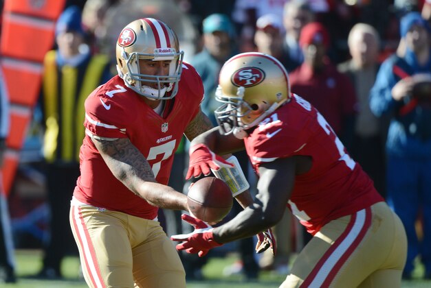 December 8, 2013; San Francisco, CA, USA; San Francisco 49ers quarterback Colin Kaepernick (7) hands the football off to running back Frank Gore (21) against the Seattle Seahawks during the first quarter at Candlestick Park. Mandatory Credit: Kyle Terada-USA TODAY Sports