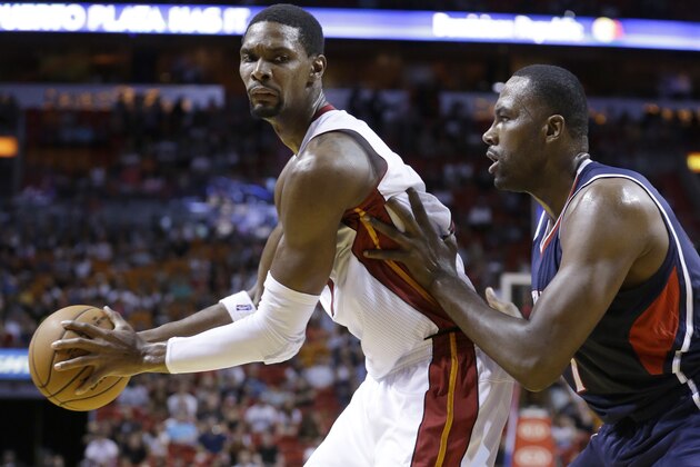 Miami Heat forward Chris Bosh, left, looks for an opening past Atlanta Hawks forward Elton Brand during the second half of a preseason NBA basketball game, Tuesday, Oct. 14, 2014 in Miami. The Hawks defeated the Heat 109-103. (AP Photo/Wilfredo Lee)
