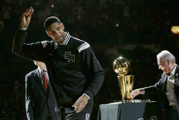 San Antonio Spurs' Tim Duncan, left, holds up his 2014 NBA championship ring during a ceremony prior to an NBA basketball game between the Spurs and the Dallas Mavericks, Tuesday, Oct. 28, 2014, in San Antonio. (AP Photo/Eric Gay)