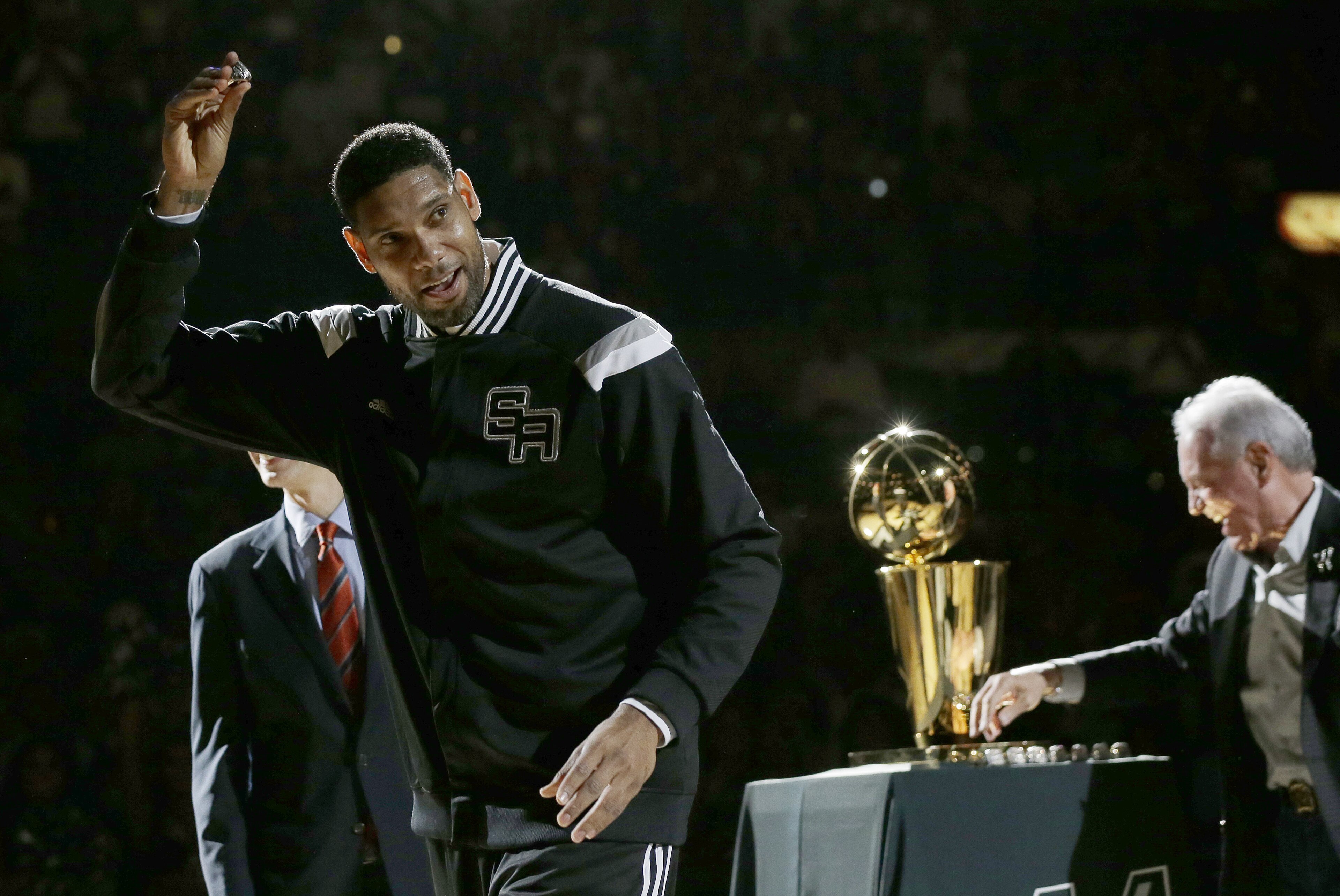 San Antonio Spurs' Tim Duncan, left, holds up his 2014 NBA championship ring during a ceremony prior to an NBA basketball game between the Spurs and the Dallas Mavericks, Tuesday, Oct. 28, 2014, in San Antonio. (AP Photo/Eric Gay)