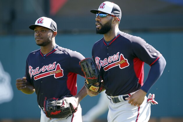 Atlanta Braves fielders Justin Upton, left, and Jason Heyward jog off the field during a spring training baseball workout, Sunday, Feb. 16, 2014, in Kissimmee, Fla. (AP Photo/Alex Brandon)