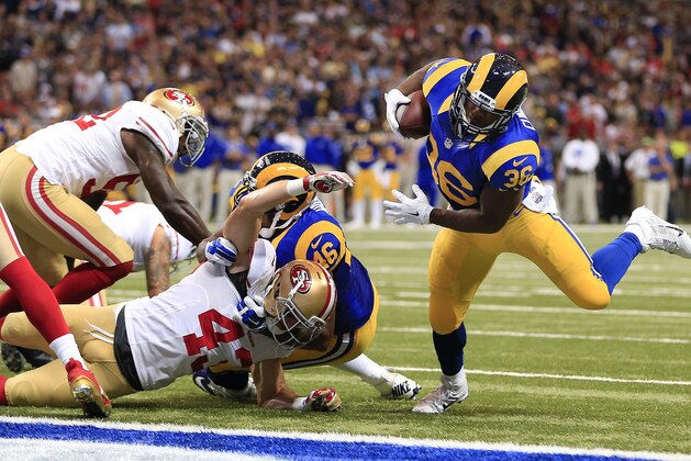 St. Louis Rams running back Benny Cunningham (36) scores a touchdown as Rams tight end Cory Harkey (46) blocks San Francisco 49ers strong safety Craig Dahl (43) in the first quarter of an NFL football game Monday, Oct. 13, 2014, in St Louis. (AP Photo/Billy Hurst)