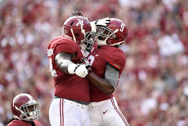 Sep 13, 2014; Tuscaloosa, AL, USA;  Alabama Crimson Tide offensive linesman Cam Robinson (74) leaps up to celebrate wide receiver Amari Cooper (9) touchdown against the Southern Miss Golden Eagles during the first quarter at Bryant-Denny Stadium. Mandatory Credit: John David Mercer-USA TODAY Sports