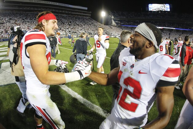Ohio State defensive lineman Joey Bosa (97) celebrates with cornerback Doran Grant (12) after getting a 31-24 win in double overtime of an NCAA college football game against Penn State in State College, Pa., Saturday, Oct. 25, 2014. (AP Photo/Gene J. Puskar)
