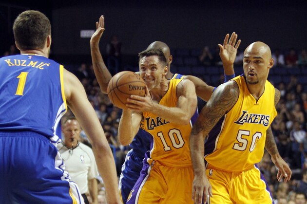 Los Angeles Lakers guard Steve Nash (10) takes a shot with center Robert Sacre (50) looking on against Golden State Warriors center Ognjen Kuzmic (1), of Bosnia, and guard Leandro Barbosa, of Brazil, from behind during the first half of a preseason NBA basketball game, Sunday, Oct. 12, 2014, in Ontario, Calif. (AP Photo/Alex Gallardo)
