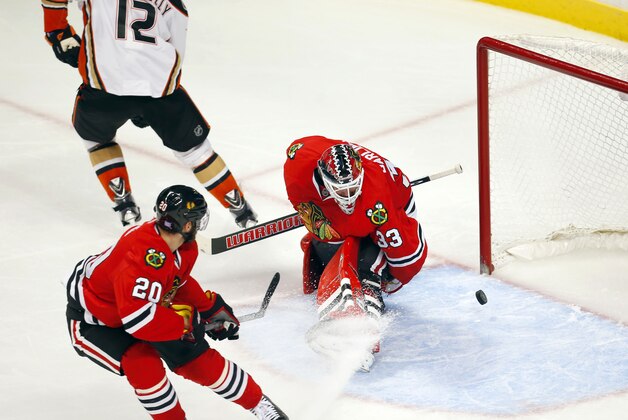 Chicago Blackhawks goalie Scott Darling (33) and teammate Brandon Saad (20) watch the puck go into the goal shot by Anaheim Ducks Devante Smith-Pelly (12) during the third period of an NHL hockey game Tuesday, Oct. 28, 2014, in Chicago. The Ducks won 1-0. (AP Photo/Jeff Haynes)
