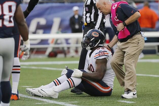 Chicago Bears defensive end Lamarr Houston, seated, receives attention after injuring his knee while celebrating a sack on New England Patriots backup quarterback Jimmy Garoppolo with about 3 minutes left in an NFL football game on Sunday, Oct. 26, 2014, in Foxborough, Mass. The Patriots won 51-23.  (AP Photo/Elise Amendola)