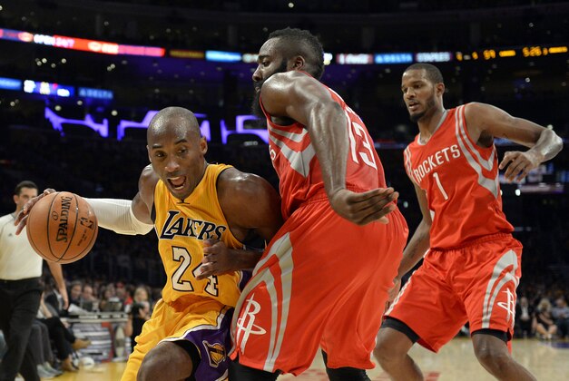 Oct 28, 2014; Los Angeles, CA, USA; Los Angeles Lakers guard Kobe Bryant (24) drives against Houston Rockets guard James Harden (13) and guard Trevor Ariza (1) during the second half at Staples Center. Mandatory Credit: Richard Mackson-USA TODAY Sports