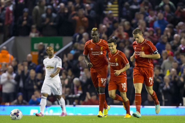 Liverpool's Mario Balotelli, centre left, celebrates with teammates after scoring against Swansea during the English League Cup soccer match between Liverpool and Swansea at Anfield Stadium, Liverpool, England, Tuesday Oct. 28, 2014. (AP Photo/Jon Super)