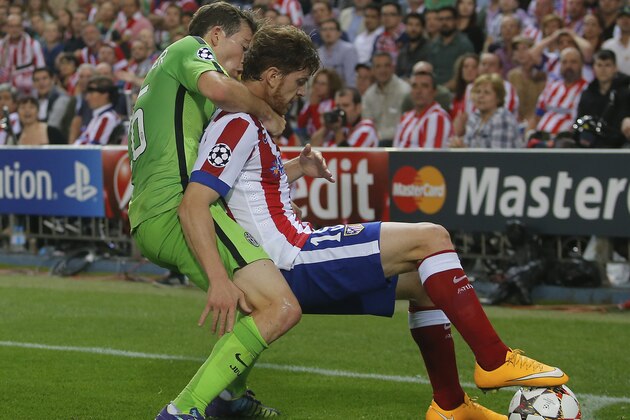 Atletico's Cristian Ansaldi, right, is grabbed from behind by Juventus' Stephan Lichtsteiner during the Group A Champions League soccer match between Atletico de Madrid and Juventus at the Vicente Calderon stadium in Madrid, Spain, Wednesday Oct. 1, 2014. (AP Photo/Andres Kudacki)