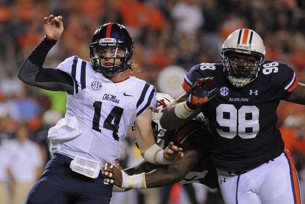 Oct 5, 2013; Auburn, AL, USA; Mississippi Rebels quarterback Bo Wallace (14) is tackled by Auburn Tigers defensive end Carl Lawson (55) and  defensive lineman Angelo Blackson (98) at Jordan Hare Stadium. The Tigers defeated the Rebels 33-20. Mandatory Credit: Shanna Lockwood-USA TODAY Sports