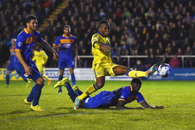 SHREWSBURY, ENGLAND - OCTOBER 28:  Jermaine Grandison of Shrewsbury Town heads the ball clear of Didier Drogba of Chelsea to score an own goal during the Capital One Cup Fourth Round match between Shrewsbury Town and Chelsea at Greenhous Meadow on October 28, 2014 in Shrewsbury, England.  (Photo by Laurence Griffiths/Getty Images)