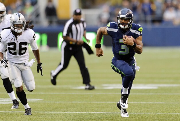 Aug 29, 2013; Seattle, WA, USA; Seattle Seahawks quarterback Russell Wilson (3) runs with the ball while being chased by Oakland Raiders free safety Usama Young (26) during the 1st half at CenturyLink Field. Seattle defeated Oakland 22-6. Mandatory Credit: Steven Bisig-USA TODAY Sports