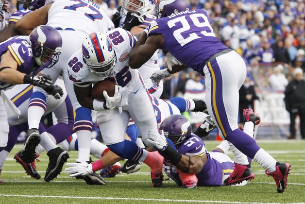 Oct 19, 2014; Orchard Park, NY, USA; Buffalo Bills running back Anthony Dixon (26) runs the ball while Minnesota Vikings cornerback Xavier Rhodes (29) looks to make a tackle during the first half at Ralph Wilson Stadium. Mandatory Credit: Timothy T. Ludwig-USA TODAY Sports
