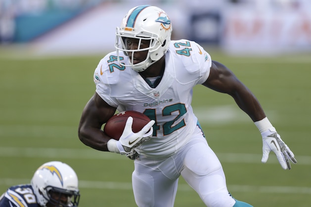 Miami Dolphins tight end Charles Clay (42) runs with the ball after escaping a tackle by San Diego Chargers strong safety Marcus Gilchrist (38) during the first half of an NFL football game, Sunday, Nov. 17, 2013, in Miami Gardens, Fla. (AP Photo/Wilfredo Lee)