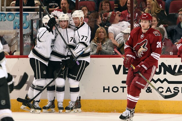 GLENDALE, AZ - OCTOBER 11:  Tanner Pearson #70 of the Los Angeles Kings (C)  celebrates his goal with teammates Tyler Toffoli #73 and Jeff Carter #77 as Lauri Korpikoski #28 of the Arizona Coyotes skates by during the first period at Gila River Arena on October 11, 2014 in Glendale, Arizona.  (Photo by Norm Hall/NHLI via Getty Images)