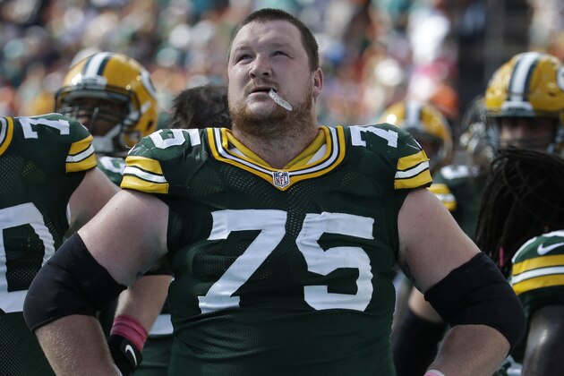 Green Bay Packers tackle Bryan Bulaga (75) looks up from the sidelines during the second half of an NFL football game against the Miami Dolphins, Sunday, Oct. 12, 2014, in Miami Gardens, Fla. (AP Photo/Lynne Sladky)